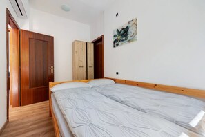 Ein Schlafzimmer mit einem hölzernen Bett, einem Kleiderschrank und einem Gemälde an der Wand.