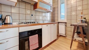 Una cucina moderna con piano cottura a gas, forno e finestra sopra il lavello.