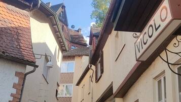 Eine enge Kopfsteinpflasterstraße, gesäumt von Gebäuden mit Schilder, darunter 'VICOLLO'.
