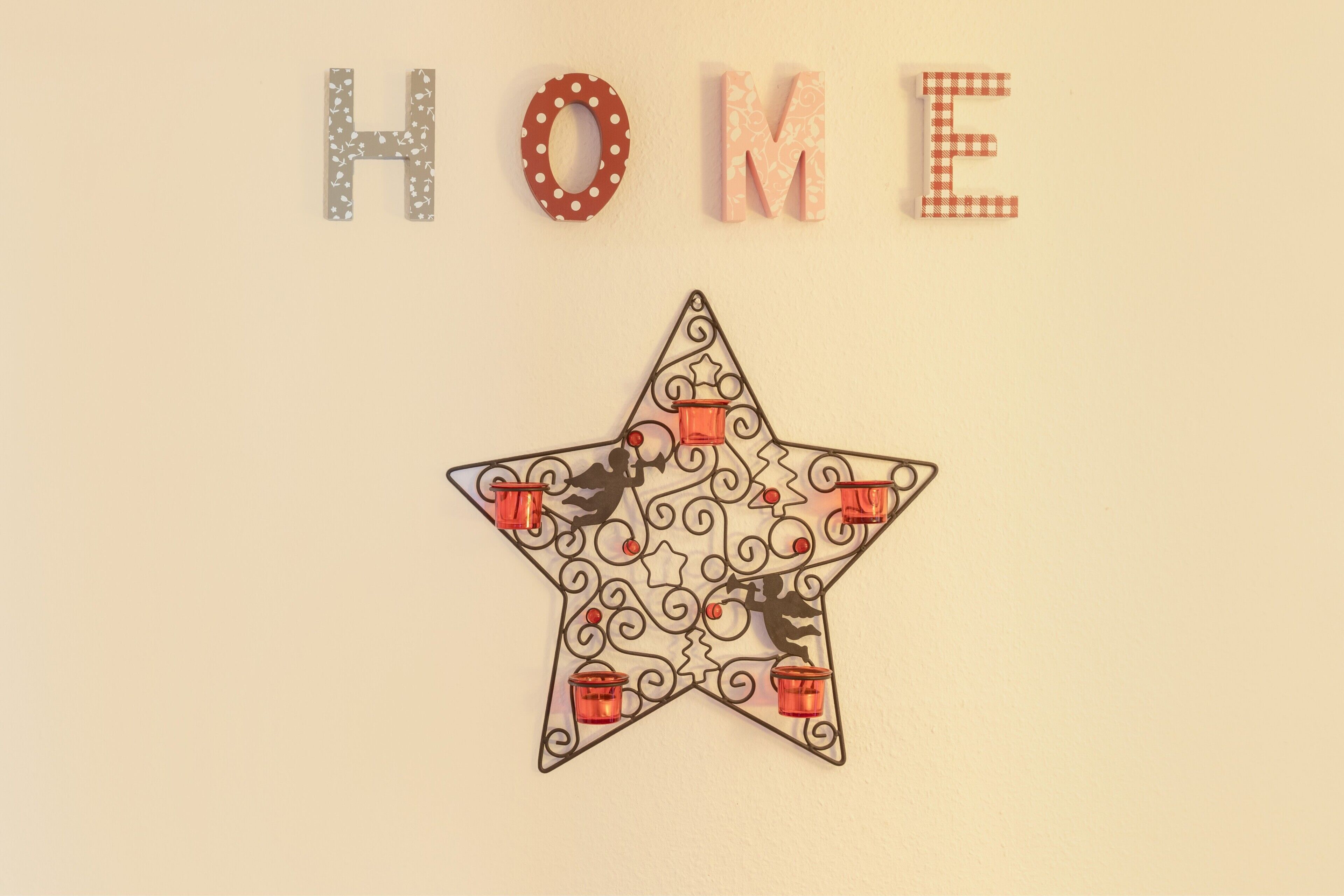 Pared con la palabra 'HOME' escrita en letras y una estrella decorativa con candelabros.