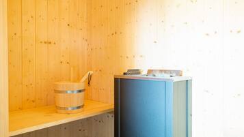 A sauna room with wooden walls, a wooden bench, and a blue sauna bench.