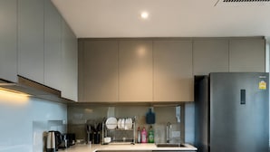 A compact kitchen with a washing machine, a refrigerator, and a sink. - 2 Bed Room Rare Unit With Bath Tub Sea View (Pattaya)