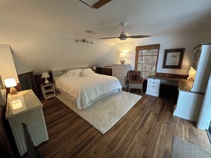 A bedroom with a bed, bedside tables, a desk, a chair, a ceiling fan, and a window with blinds. - Beautiful, private Florida home surrounded with tropical forest in Jupiter farms (Jupiter)