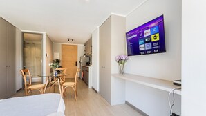 Ein modernes Hotelzimmer mit einem flachbildfernseher an der Wand, der verschiedene Streaming-Dienste anzeigt.