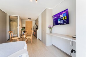 Ein modernes Hotelzimmer mit einem flachbildfernseher an der Wand, der verschiedene Streaming-Dienste anzeigt.