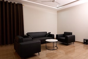 A modern living room with a sofa, two armchairs, and a coffee table.