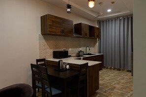 Una cocina moderna con gabinetes de madera, estufa empotrada y comedor con sillas.