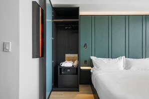 A hotel room with a bed, a wardrobe, and a small table with a lamp. - E11EVEN Studio Suite w/ Rooftop Pool City Views (Miami)