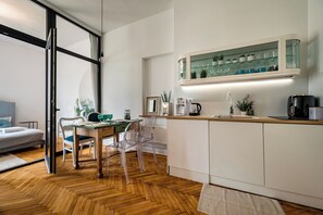 Una cocina moderna con encimera de madera, una cafetera y un armario de vidrio sobre el fregadero.