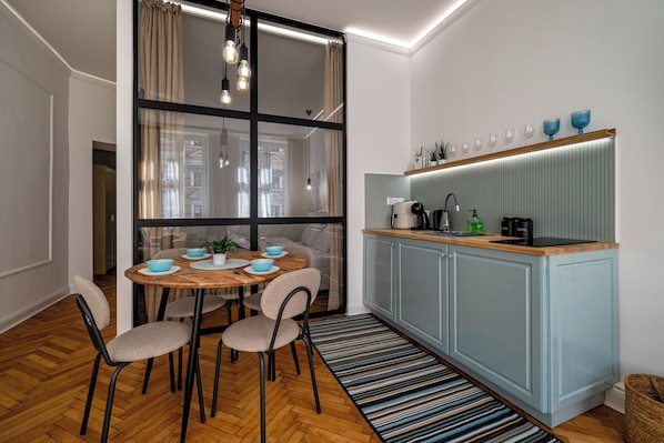 Una cocina moderna con comedor, que presenta una mesa redonda de madera, sillas y un tapete a rayas.