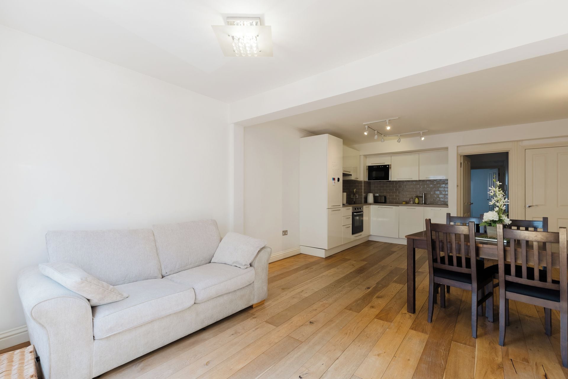 A modern apartment with a living room, a dining area, and a kitchen.