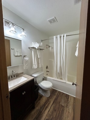 Een badkamer met een wastafel, toilet en bad.