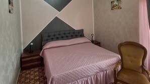 A bedroom with a bed, a chair, a wall-mounted air conditioner, and a painting.
