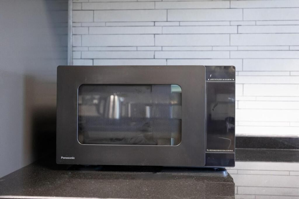 Un horno microondas Panasonic negro sobre una encimera.