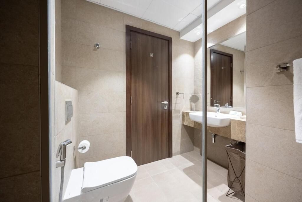 Un baño moderno con inodoro, ducha y lavabo.
