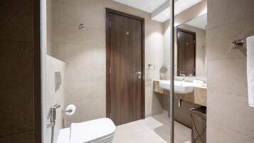 Un baño moderno con inodoro, ducha y lavabo.