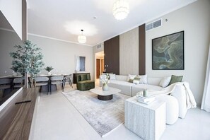 A modern living room with a sofa, coffee table, and dining area. - Bloomfields 2BR+M in Ajwan C-Saadiyat (Abu Dhabi)