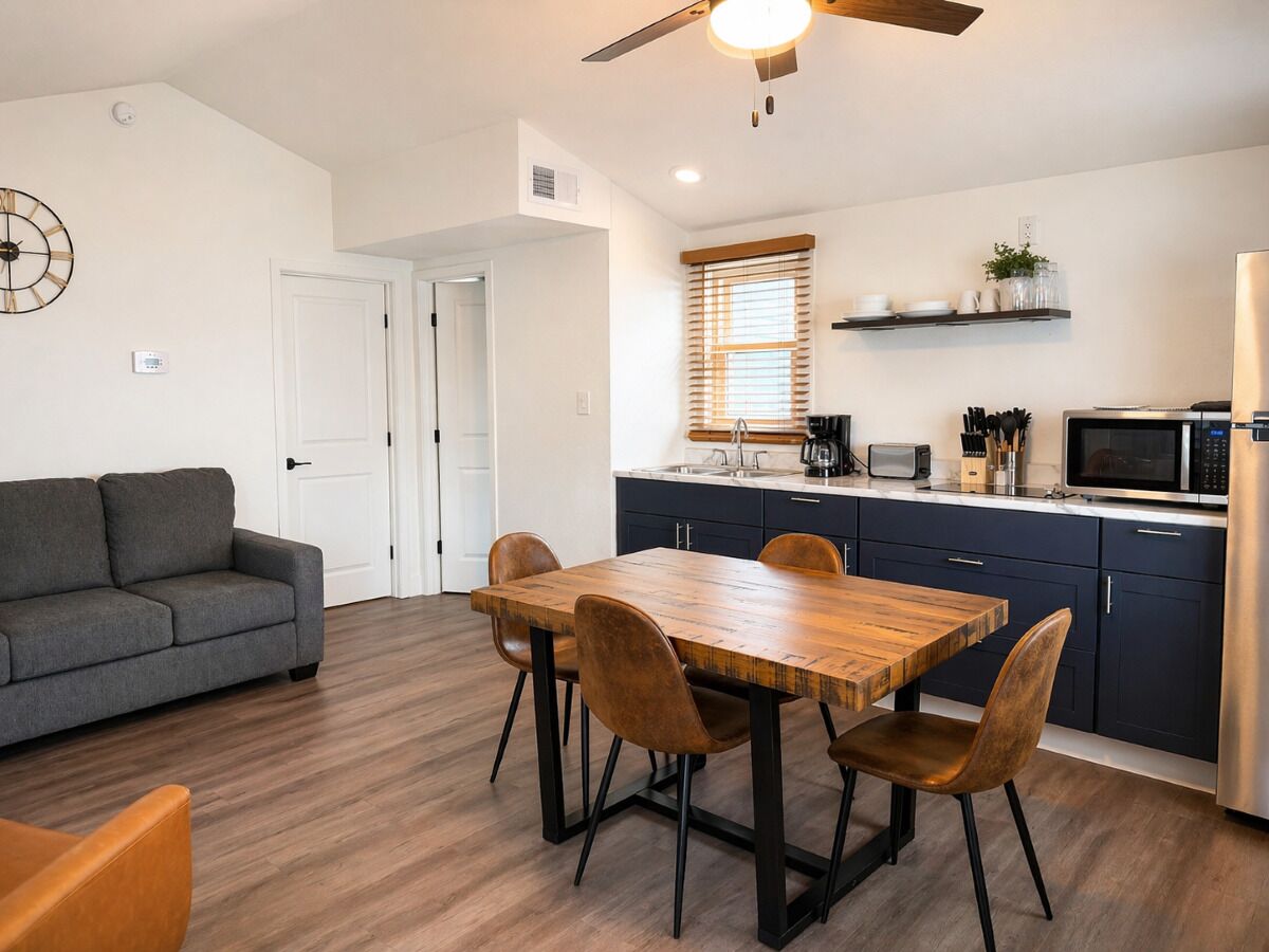 A compact living space with a dining area, kitchenette, and a sofa.