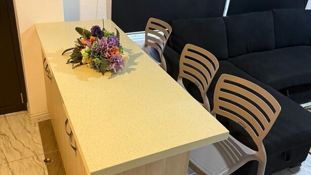 A compact living space with a kitchenette, a sofa, and a small dining table. - Cozy 2-bedroom apartment located just 5 minutes from Nadi International Airport. (Martinar)