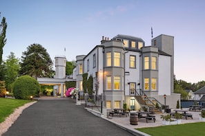 A multi-story building with a grand entrance, outdoor seating area, and a well-maintained garden. - Duchally Hotel & Country Estate (Auchterarder)