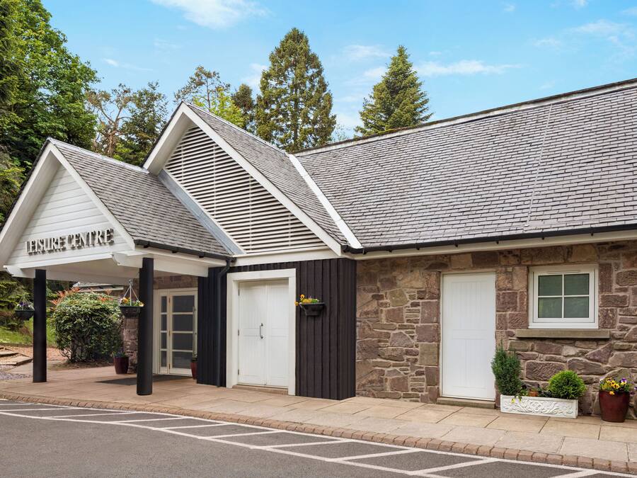 A building with a stone facade, a sloped roof, and a sign that reads 'LEISURE CENTRE'.