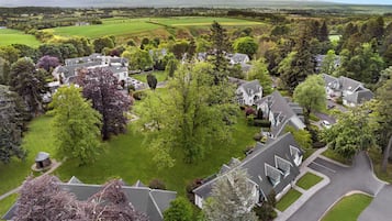 Un quartiere residenziale con case, prati verdi e alberi.