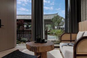 Una habitación moderna con vistas a la arquitectura tradicional, una mesa de madera y un sofá.