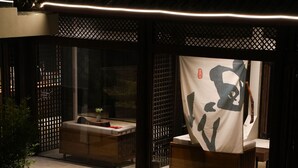 Un espace extérieur aménagé, abrité et doté d’un foyer, d’un canapé et d’une table.