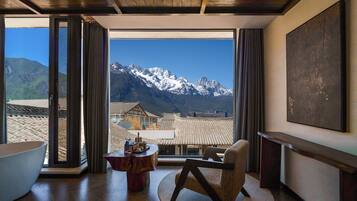 Habitación con un amplio ventanal que ofrece vistas a la montaña, techo de madera y una decoración interior moderna.