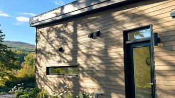 Un bâtiment moderne doté d’un toit plat, d’une porte noire et d’une fenêtre.