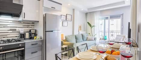 A modern kitchen with a dining area, a sofa, and a table set for a meal.
