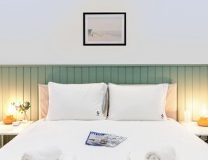 Una habitación de hotel con una cama, un cuadro en la pared y una revista sobre la cama.