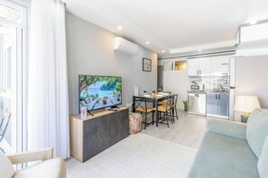 Ein modernes Wohnzimmer mit Flachbildfernseher, Esstisch und einer Sitzecke.