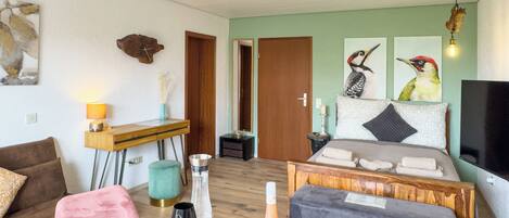 A modern bedroom with a bed, bedside table, and a television.