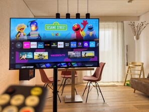 Ein Fernseher zeigt eine Kindersendung mit einer Übersicht von Streaming-Diensten.