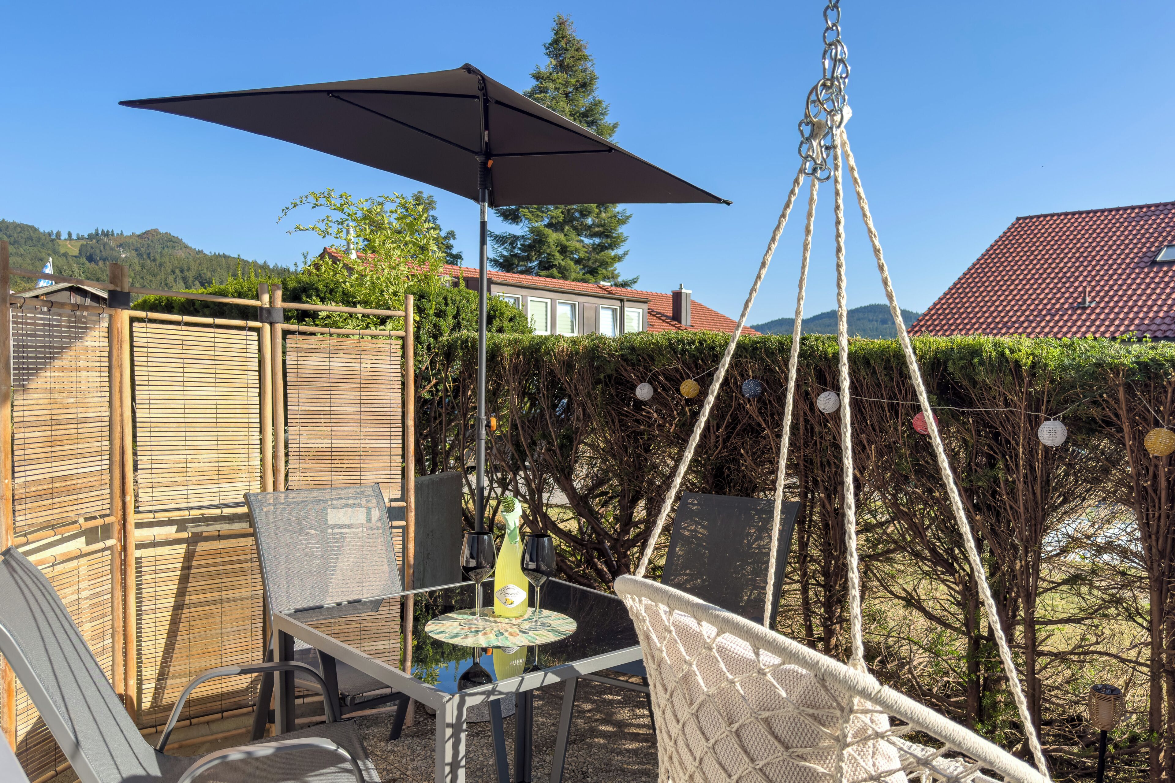 A patio with a table, chairs, and an umbrella.