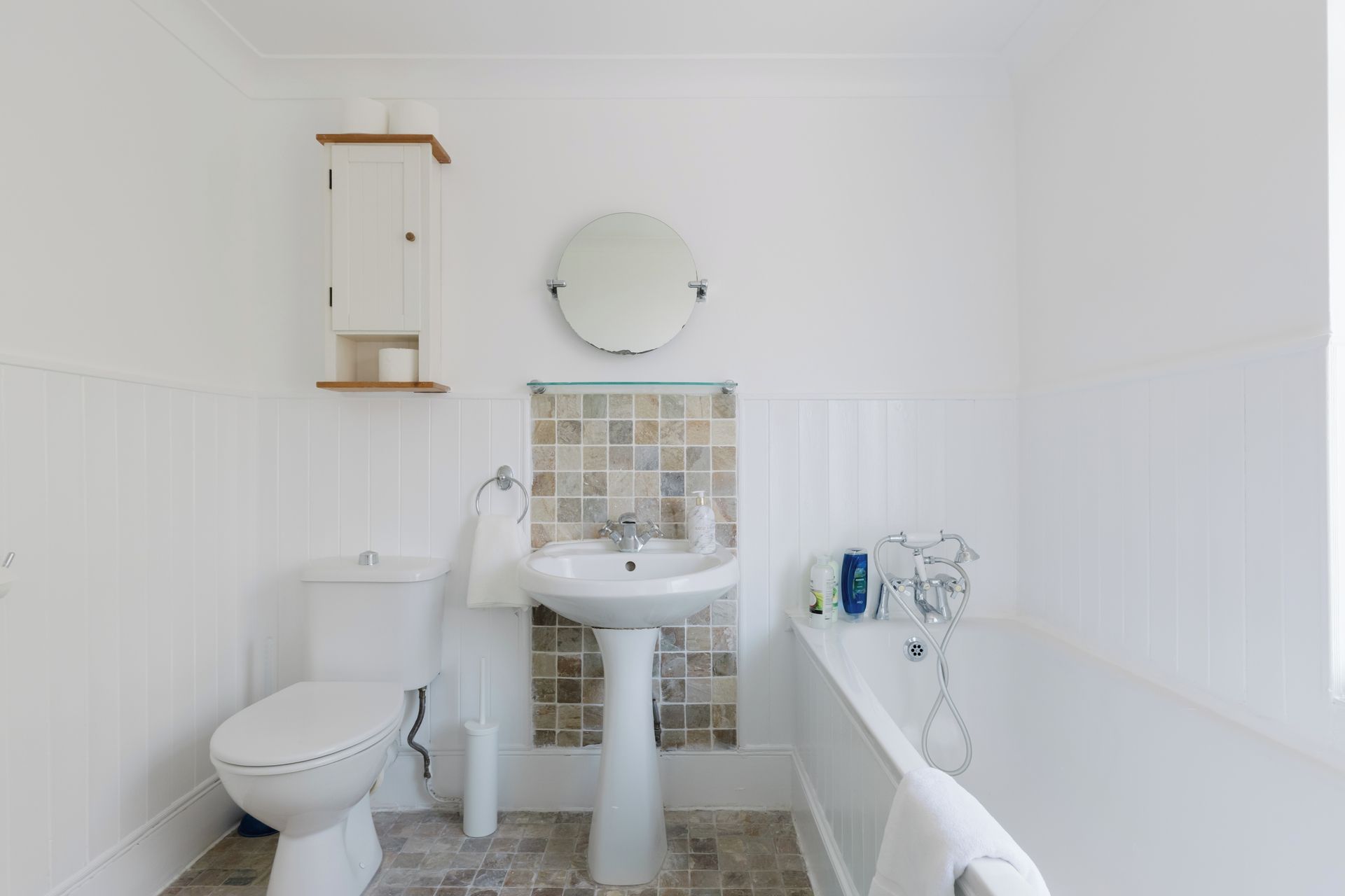 A bathroom with a toilet, sink, and bathtub.