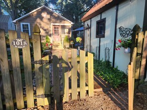 A wooden gate with a house number sign, a wooden fence, and a house with a sloped roof. - Cozy 1-bedroom apartment in quintessential Forest Hill neighborhood (Richmond)