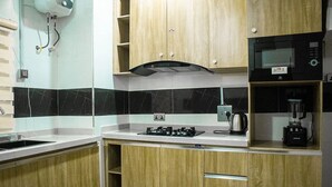 Una cocina moderna con armarios de madera, estufa a gas, microondas y cafetera.