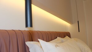A bed with a headboard, pillows, and a wall-mounted light fixture. - Mareé Boutique Stay - Pizzo VV (Pizzo)