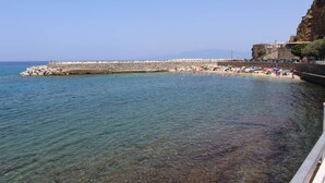 A coastal beach with clear water, a rocky breakwater, and a stone wall. - Mareé Boutique Stay - Pizzo VV (Pizzo)