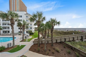 Ein Strandhotel mit Swimmingpool, Palmen und Blick auf den Strand.
