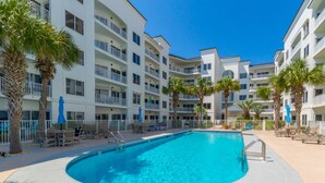 A hotel with a swimming pool surrounded by palm trees and lounge chairs. - Palm Beach D-21 (Orange Beach)
