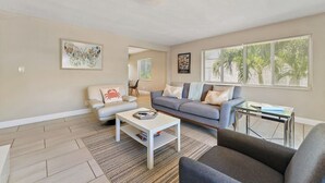 Een woonkamer met een bank, fauteuil, salontafel en een bijzettafeltje.