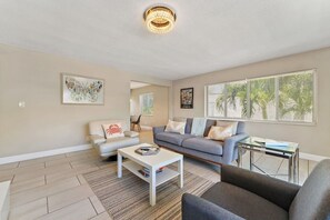 A living room with a sofa, armchair, coffee table, and a small side table. - 2BR 1BA Renovated Beach Apt in a Small Building (West Palm Beach)