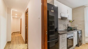 Eine moderne Küche mit Kühlschrank, Backofen und Spüle.