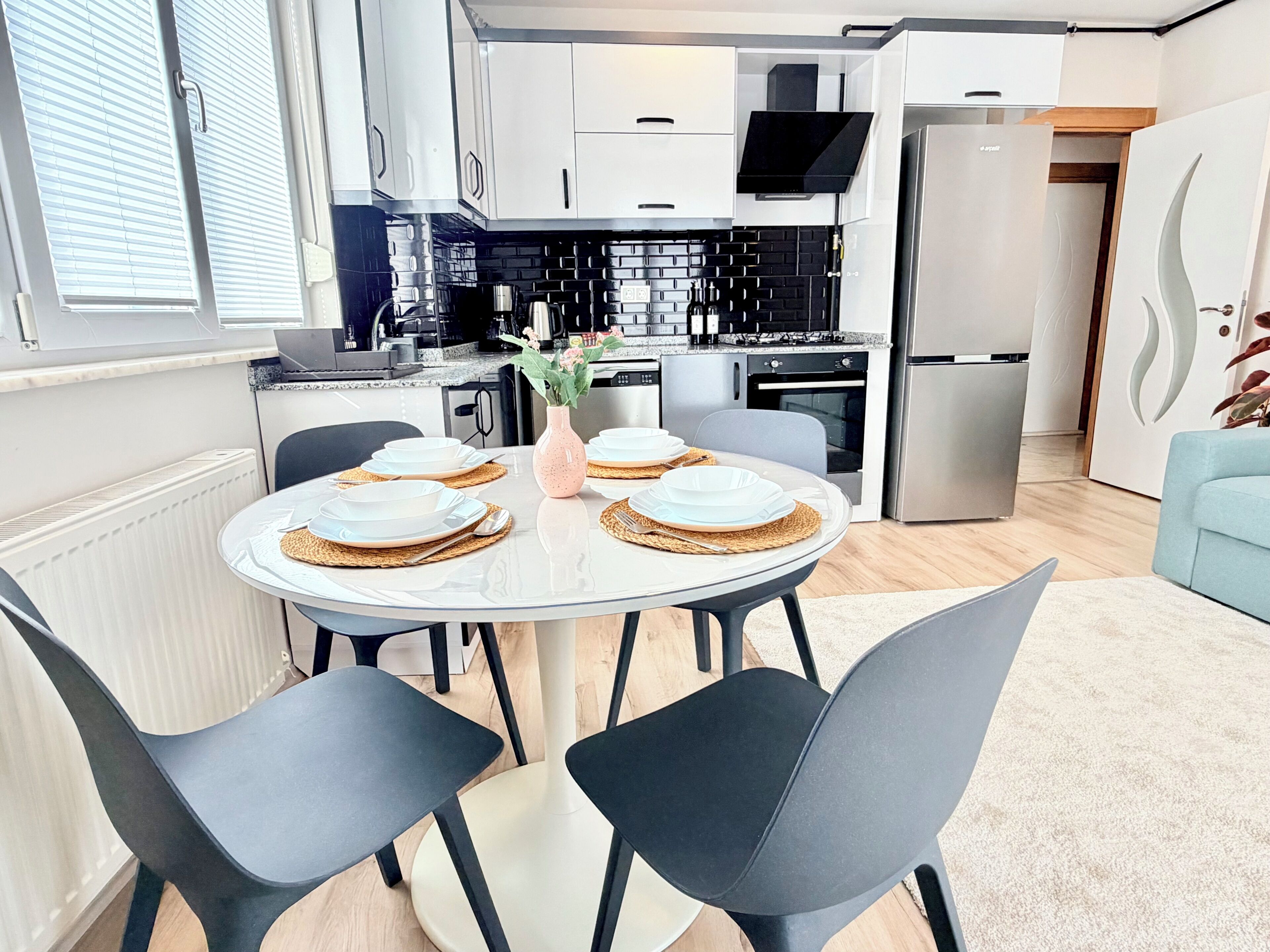 A modern kitchen with white cabinets, a black countertop, and a built-in oven.
