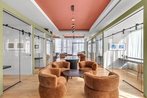A modern office space with glass walls, a round table, and comfortable seating. - Luxury Studio | Pool, Gym & Prime Location (Miami)