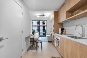 Una cocina moderna con una isla central, armarios de madera y un ventanal que ofrece vistas de la ciudad.
