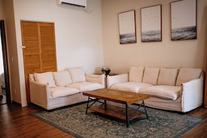 A living room with a sofa set, a coffee table, and a patterned rug.